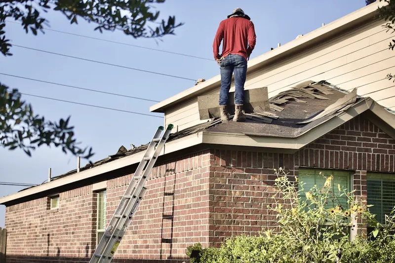 Professional roofer working on a residential roof in Lawrence